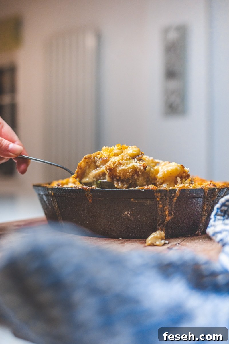 Cauliflower Cheese & Gnocchi Bake Coming being spooned from dish - Georgie Eats