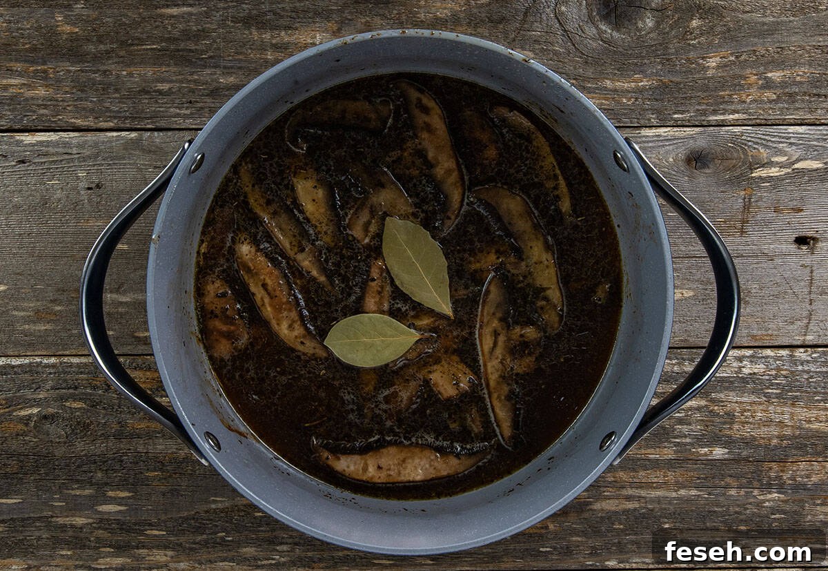 Beef broth and bay leaves added to pot.