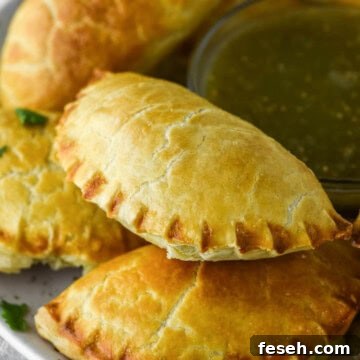 Cheese empanada stacked on other on plate.