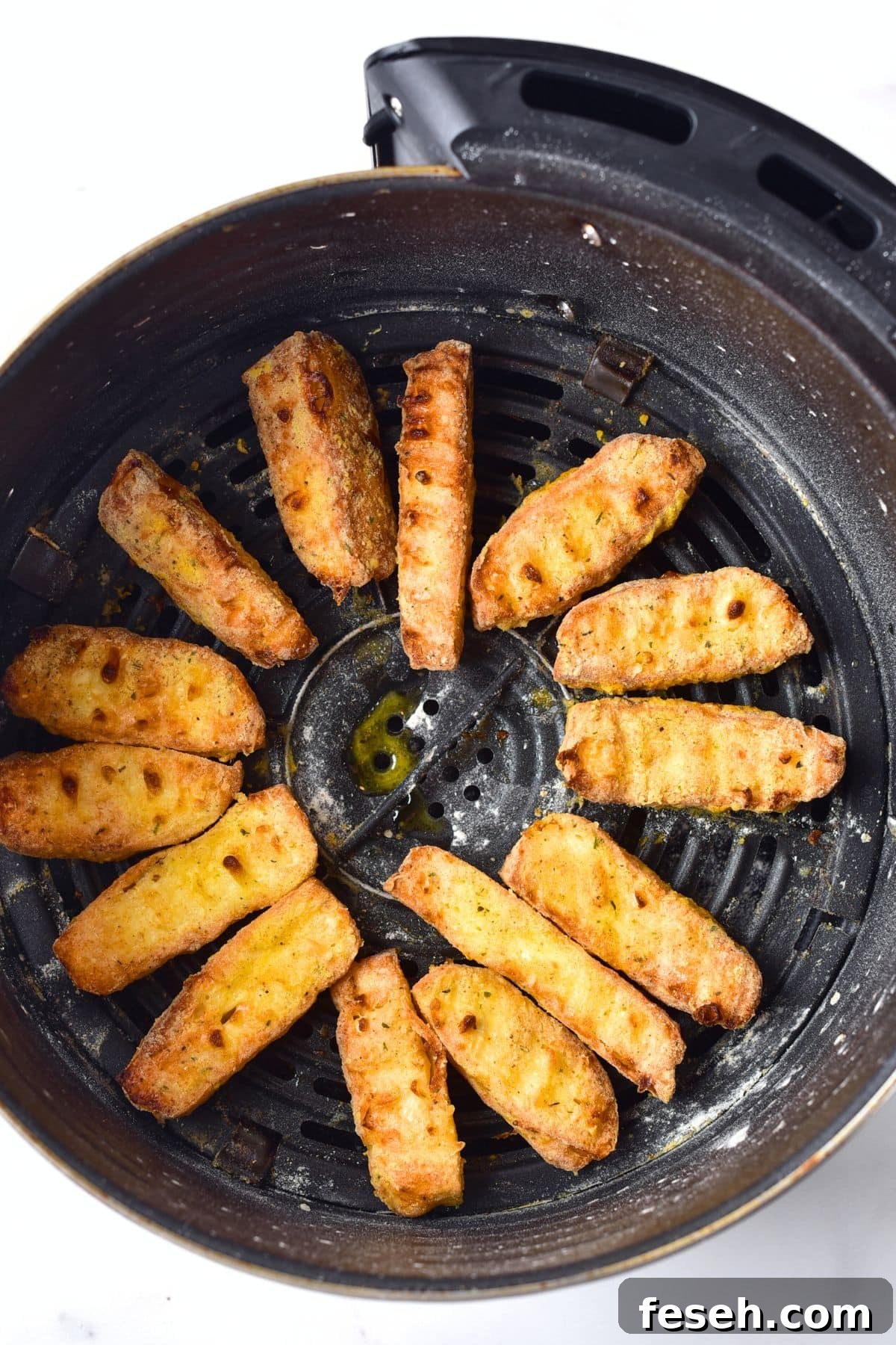 Cooked halloumi cheese fries in air fryer basket