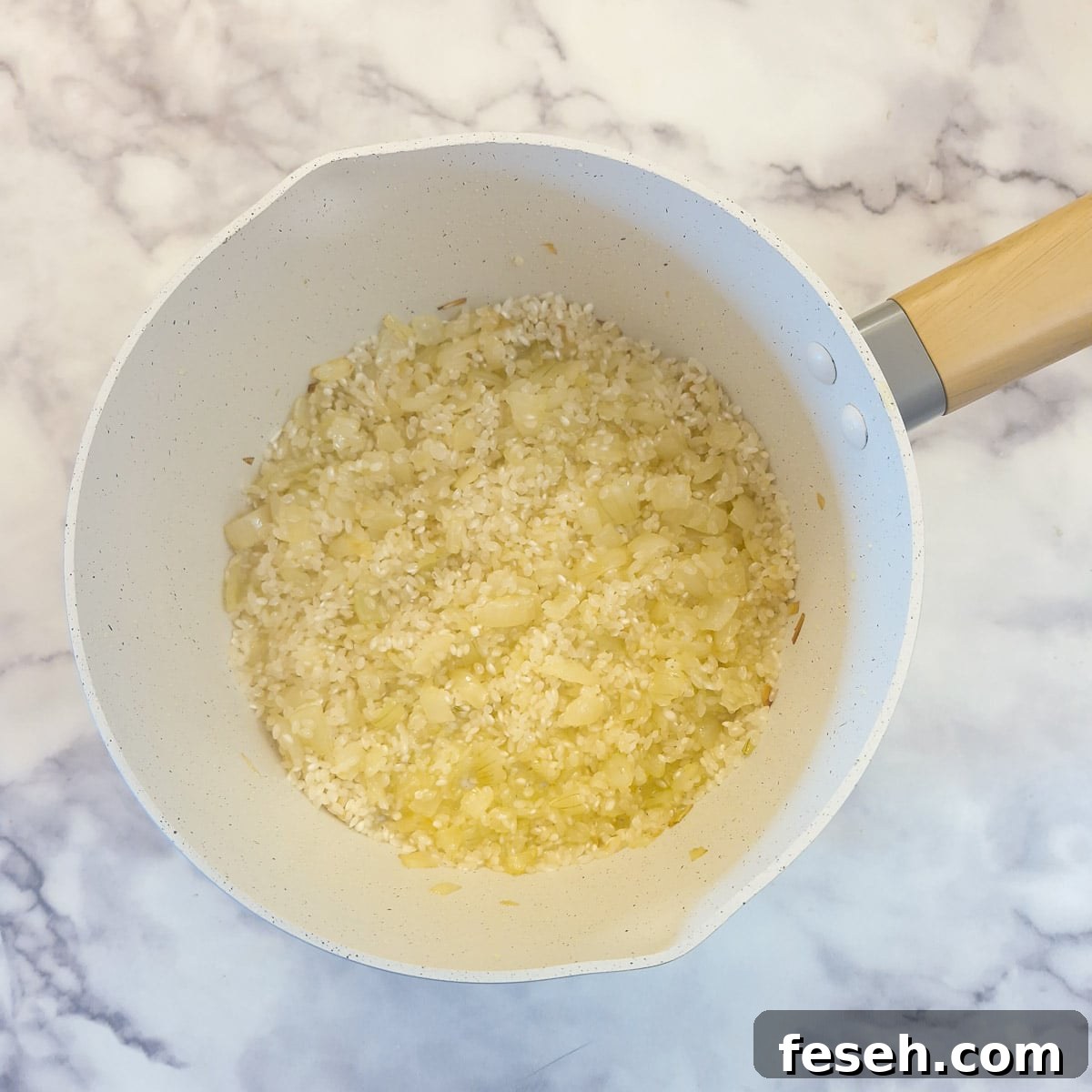 Arborio rice combined with softened onions.