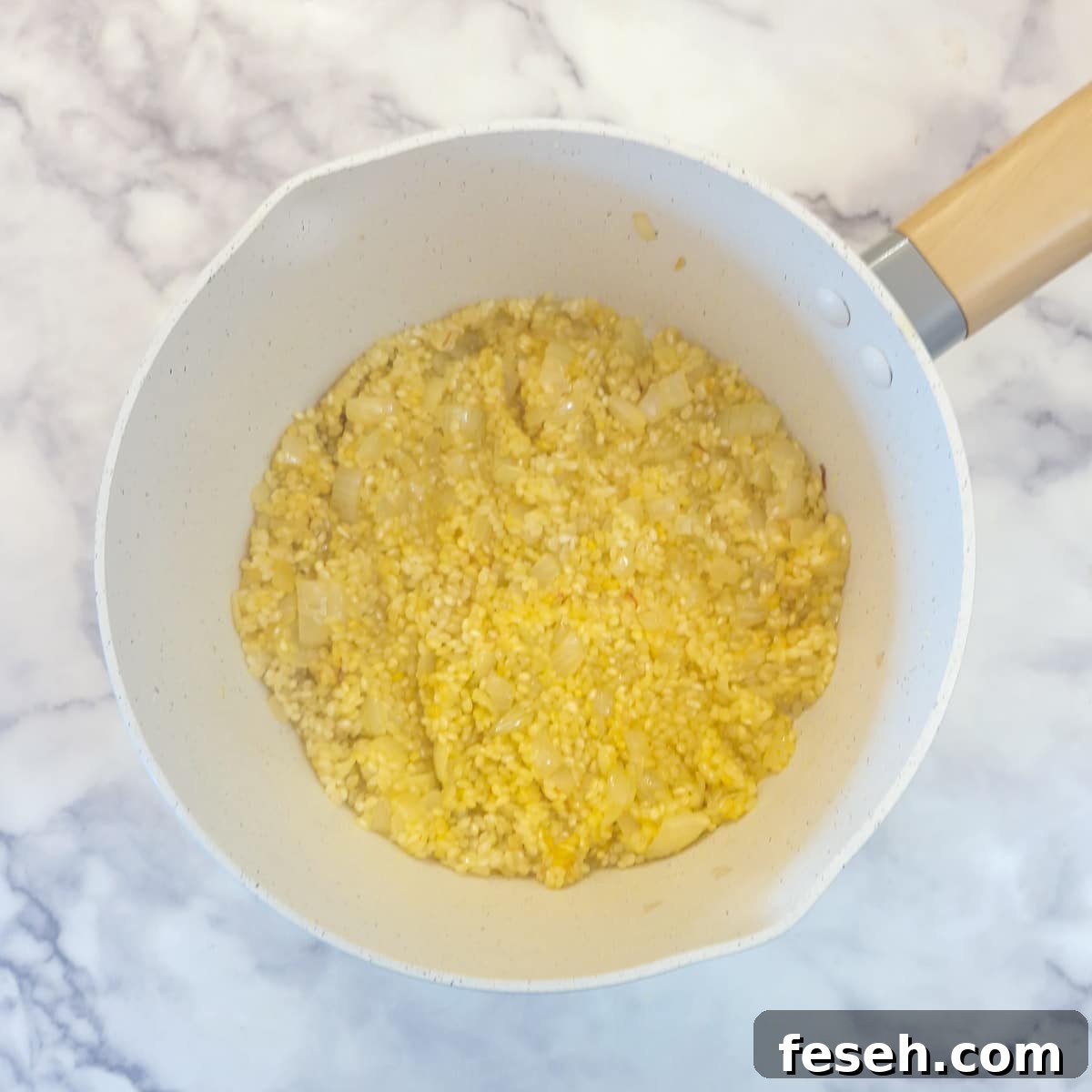 Vinegar mixture being combined with rice and onions.