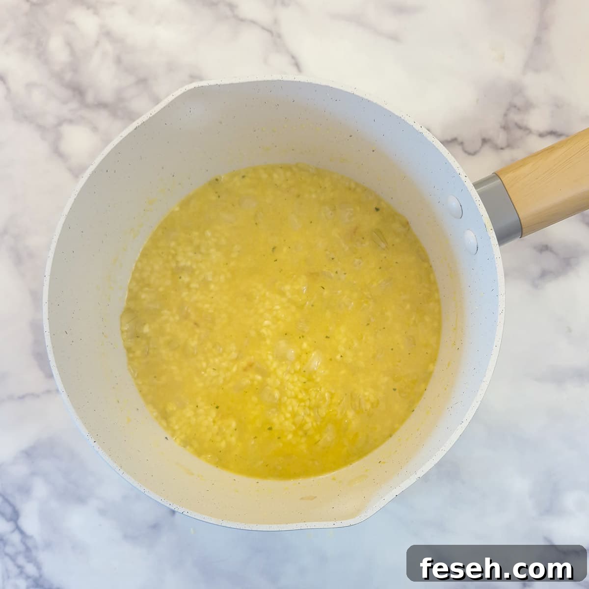 A small amount of stock added to rice in a saucepan, simmering to allow the liquid to be absorbed.
