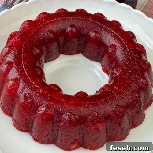 Cherry Coke Jello Salad Recipe — Retro Fizzy Dessert 9 Ring of coke cherry jello salad on a white serving tray.