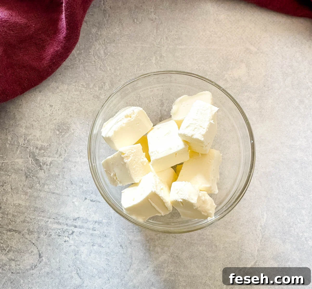 cream cheese cut into chunks in a glass bowl