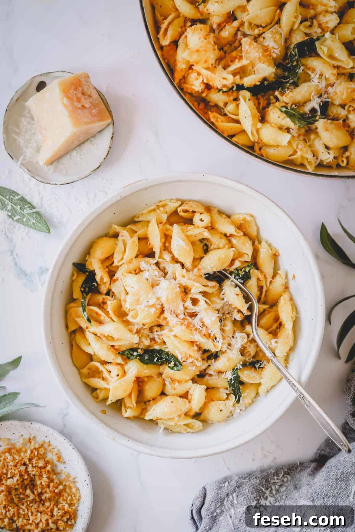A bowl of brown butter pasta topped with parmesan with a fork sticking out.