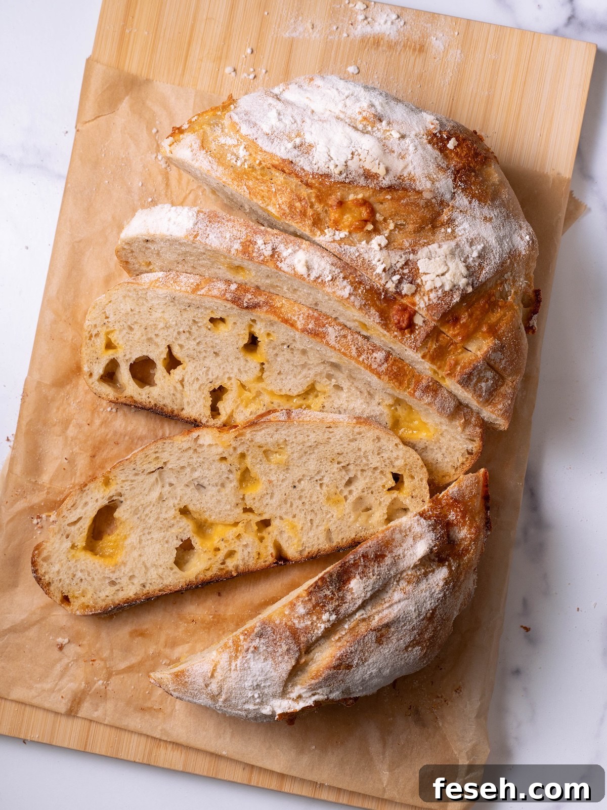 A loaf of homemade cheesy sourdough bread sliced