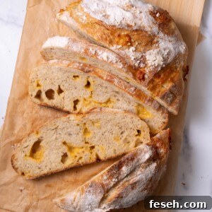 A loaf of homemade cheesy sourdough bread sliced