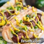 Hot dogs wrapped in bacon and topped with grilled onions, jalapenos, and Heinz Mustard