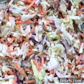 Creamy southern coleslaw (shredded carrots & cabbage covered in mayonnaise) up close.