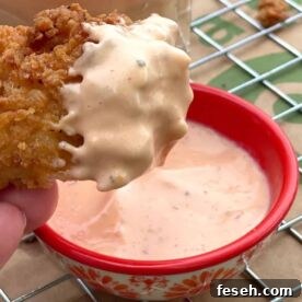 A chicken tender coated in boom boom fry sauce.