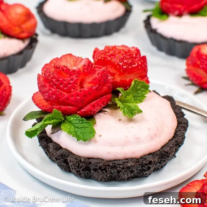 Strawberry tarts with Oreo crusts on white plates.