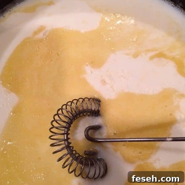 Adding flour and milk to butter to create a roux