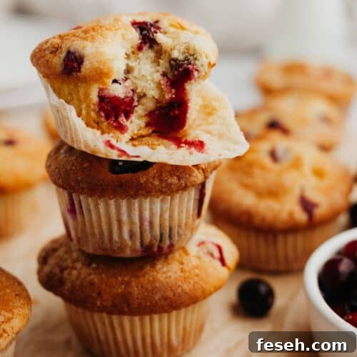 A stack of cranberry muffins on parchment paper.
