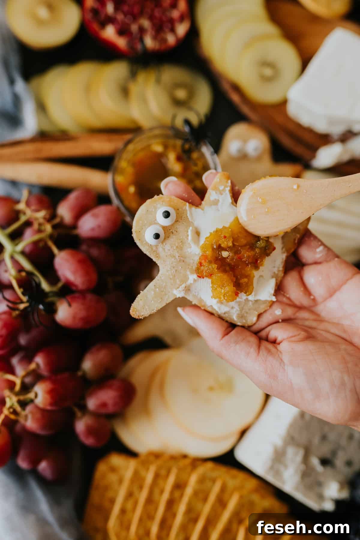 Ghost-shaped cracker topped with creamy cheese and jalapeño jelly.