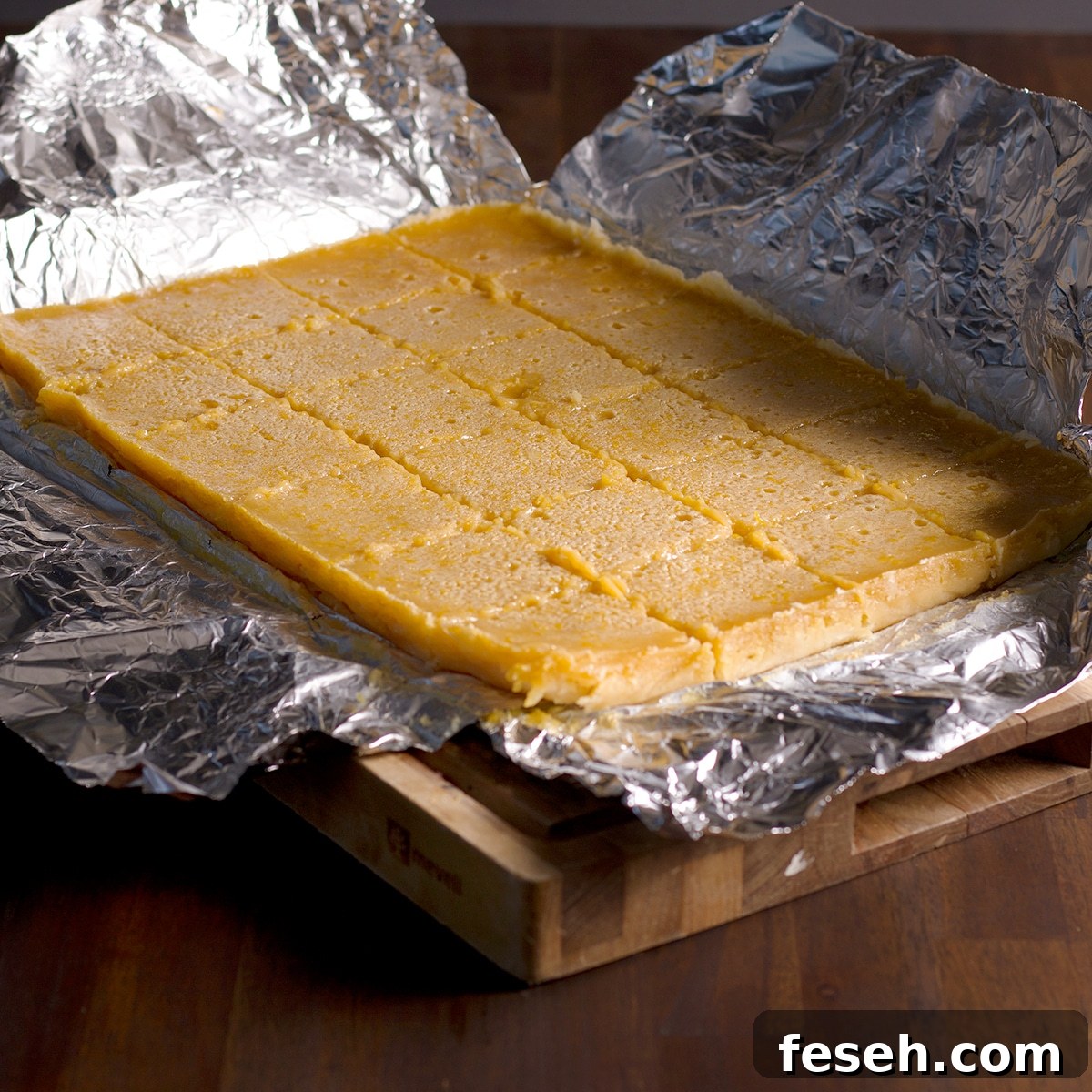 A lemon bar cake that's been cut into individual sized squares.