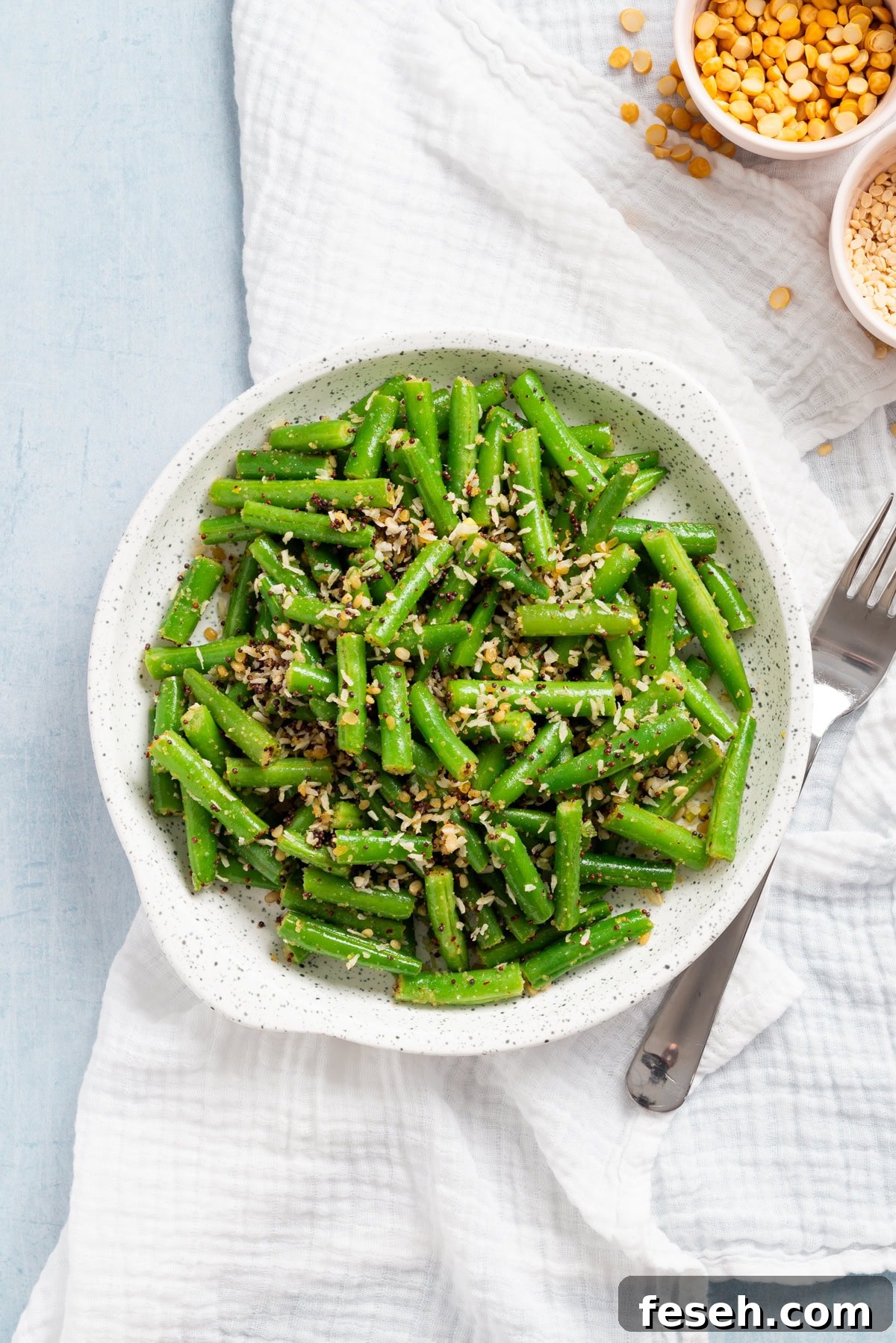 An overhead image of Indian stir fry green beans on a serving plate with a fork on the side.