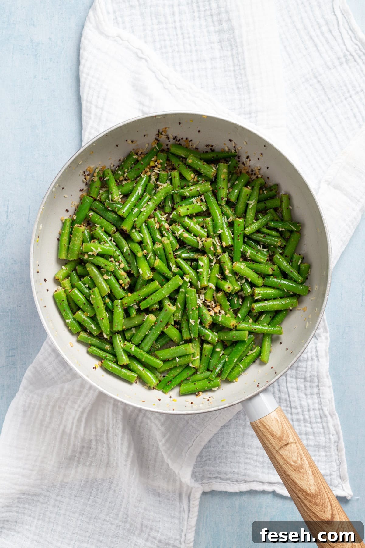 An overhead image of stir fried green beans on a skillet.