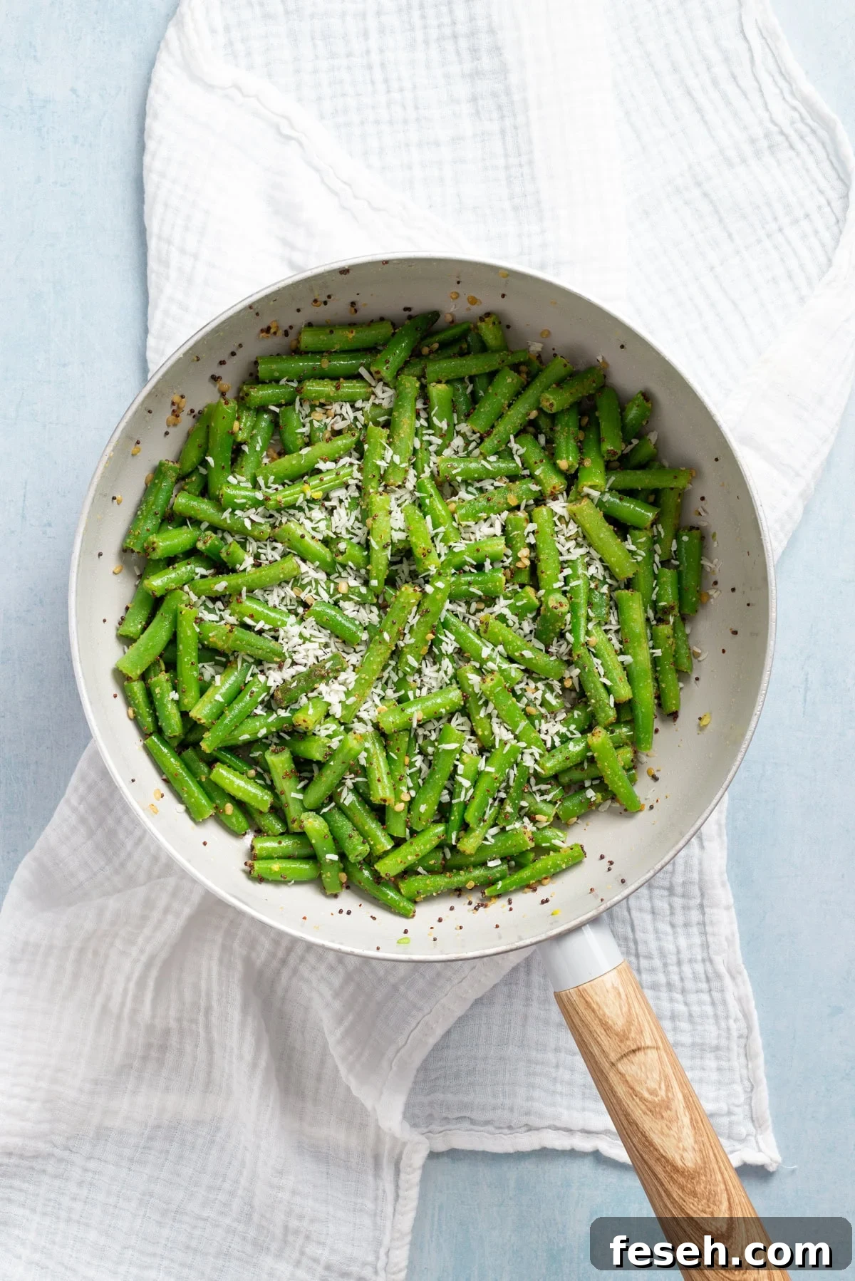 An overhead image of desiccated coconut on top of the green beans.