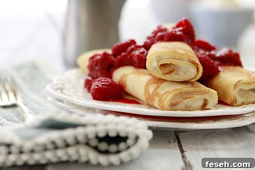 orange raspberry dessert crepes on white plates