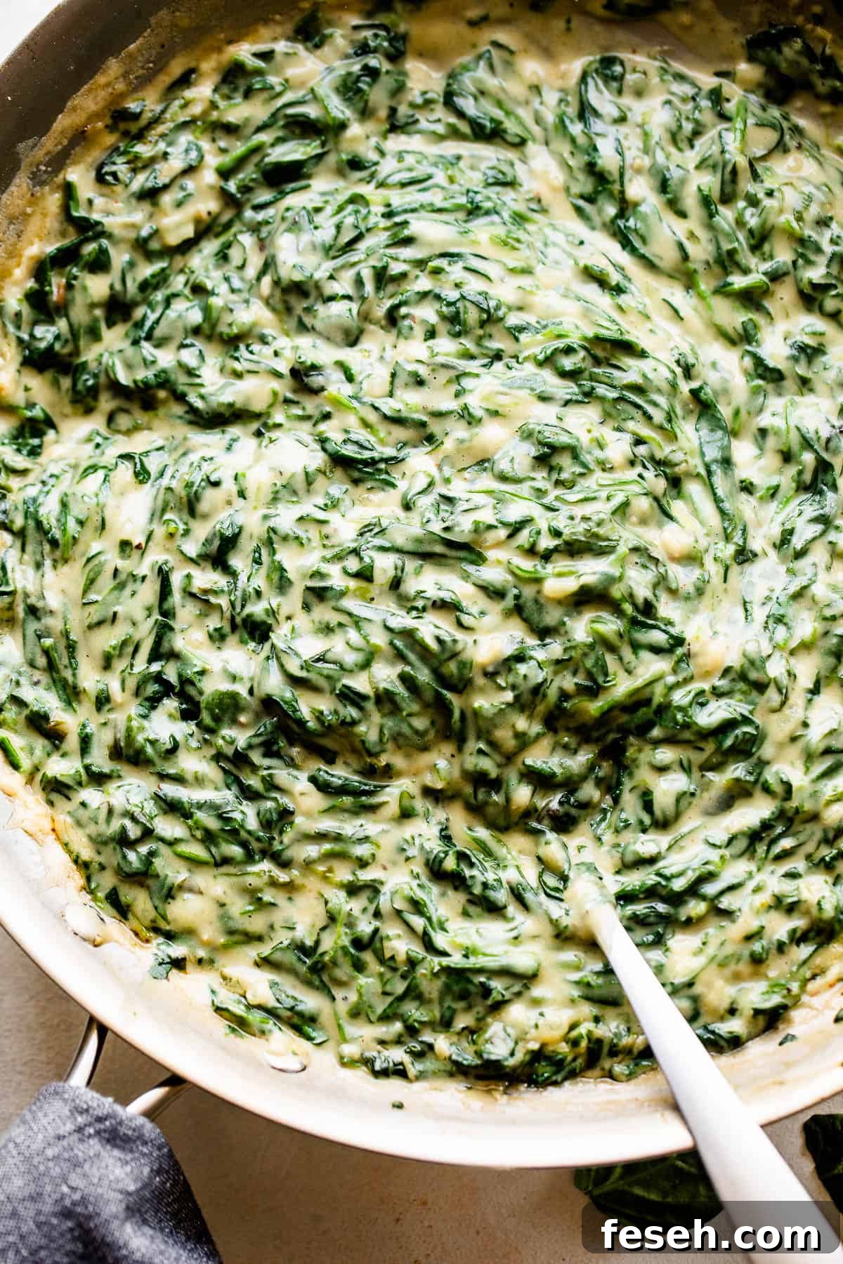 overhead picture of creamed spinach cooking in a large skillet