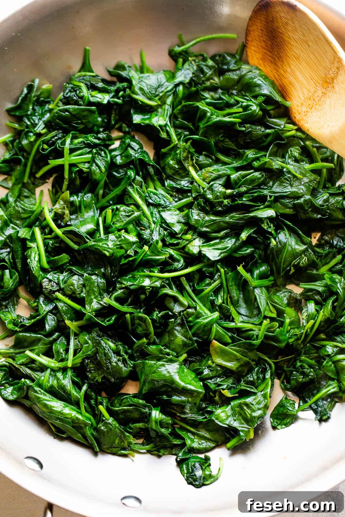 cooking spinach in stainless steel skillet