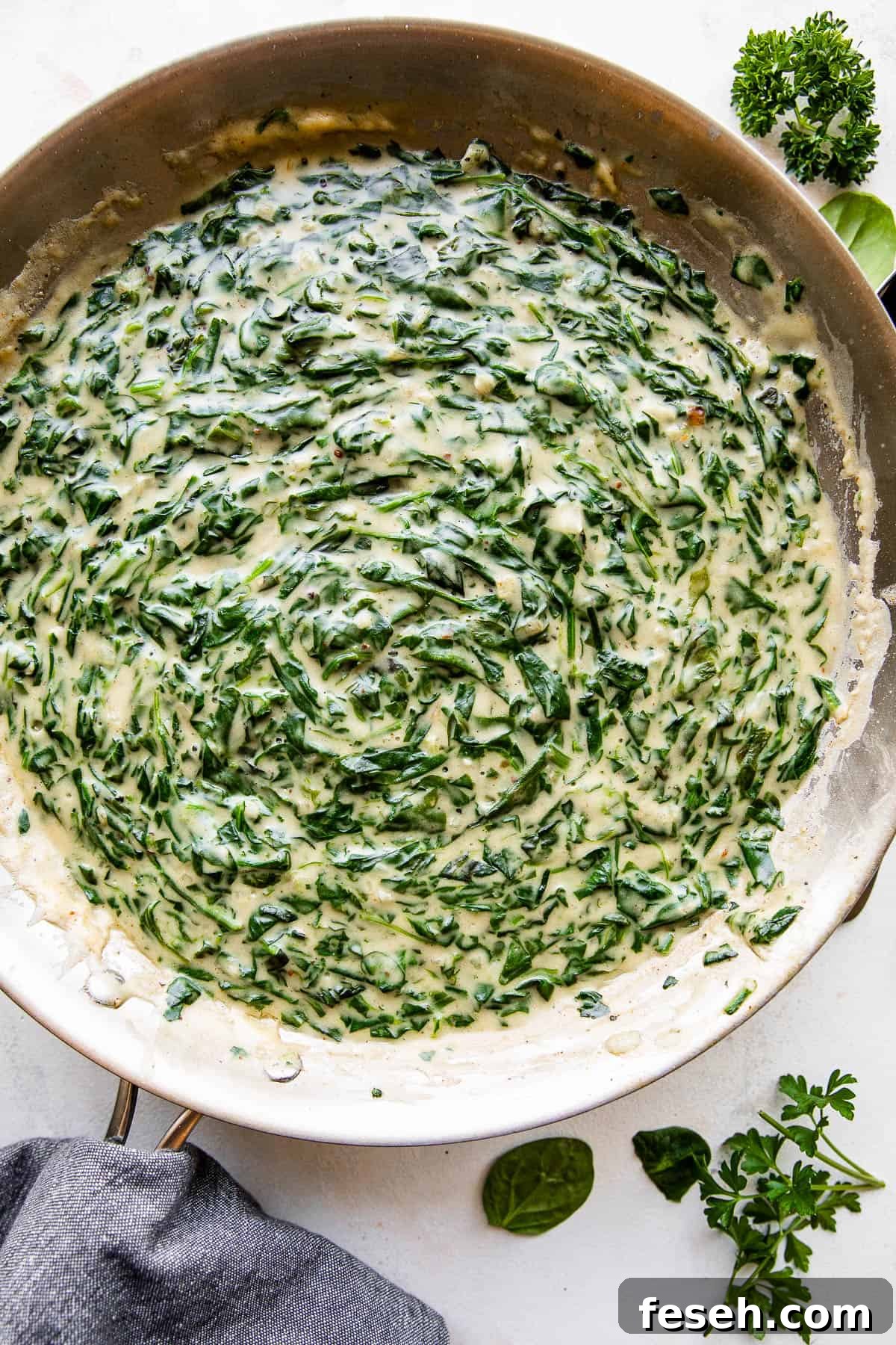 overhead picture of creamed spinach cooking in a large skillet.