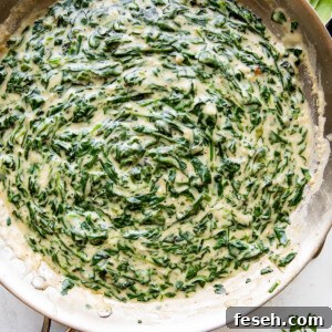 overhead picture of creamed spinach cooking in a large skillet.