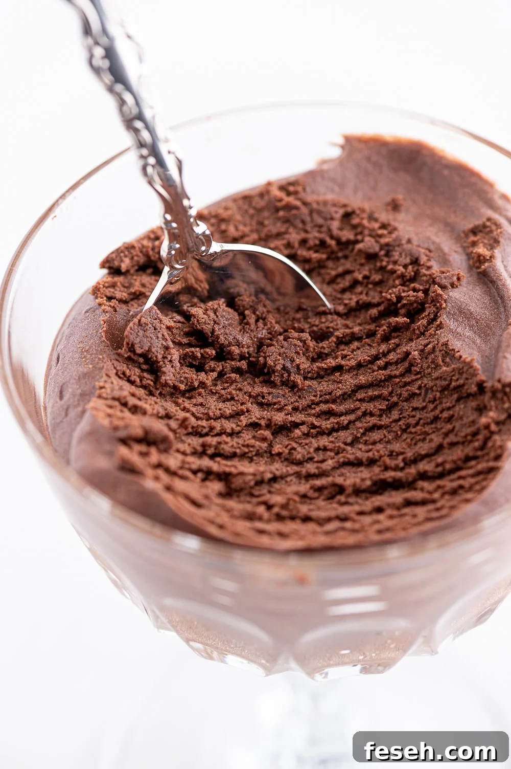A dish of dark chocolate low carb mousse with a scoop removed to show the interior texture. 