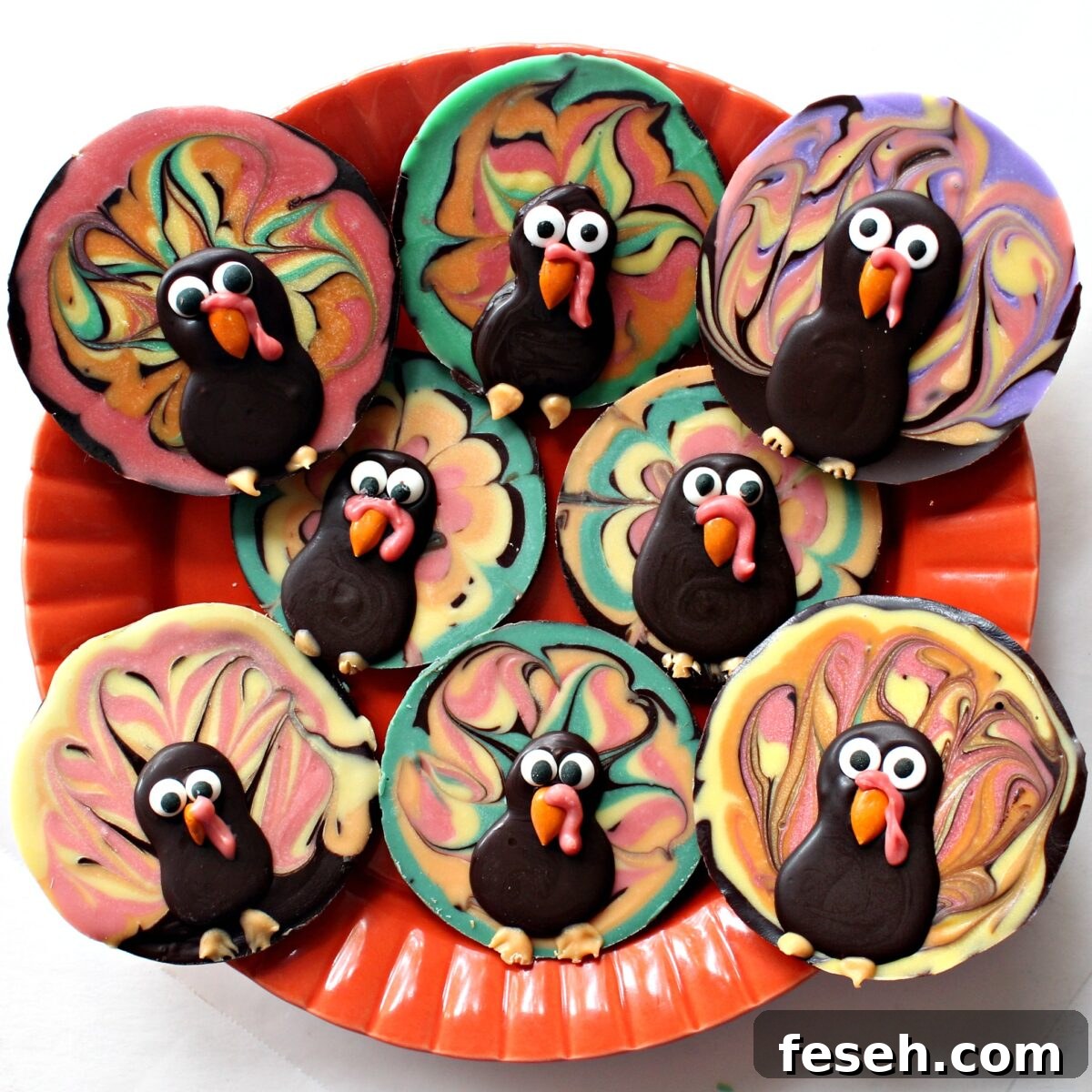 Disc shaped Thanksgiving Chocolate Turkeys made with colored and dark chocolate on a serving plate.