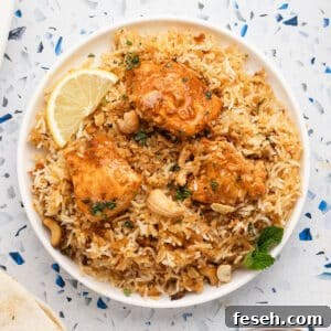 A large platter with Biryani rice topped with chicken tikka.