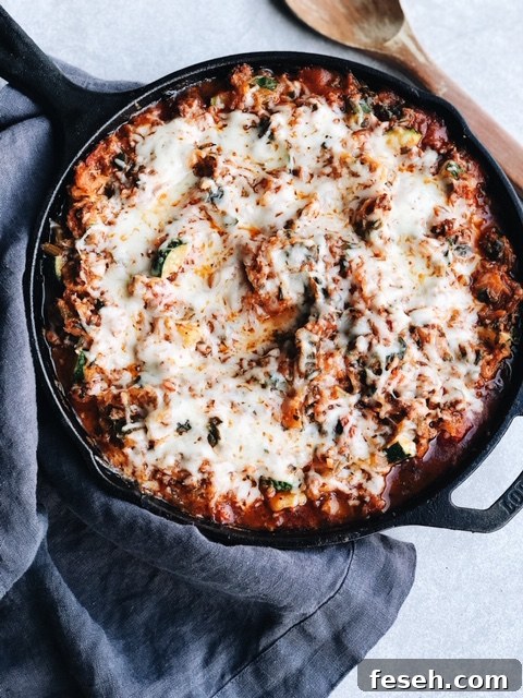 spaghetti squash bake in a cast iron pan with grey dish towel