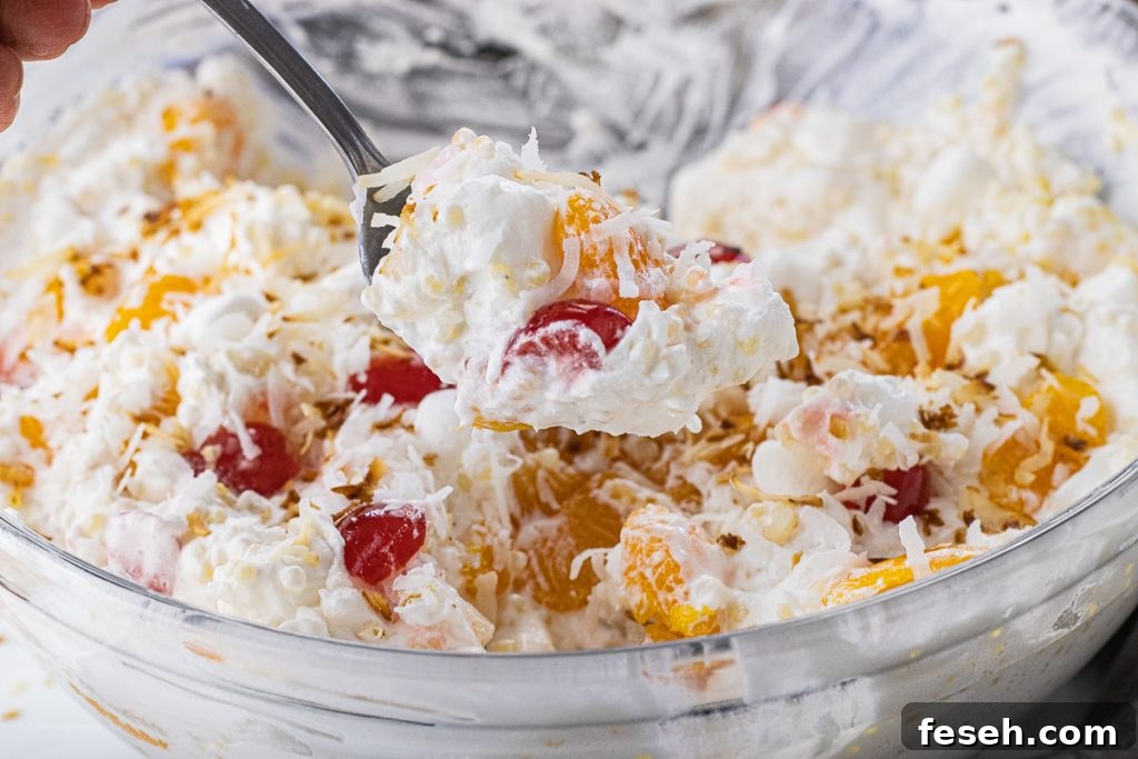spoon scooping out a spoonful of fruit salad