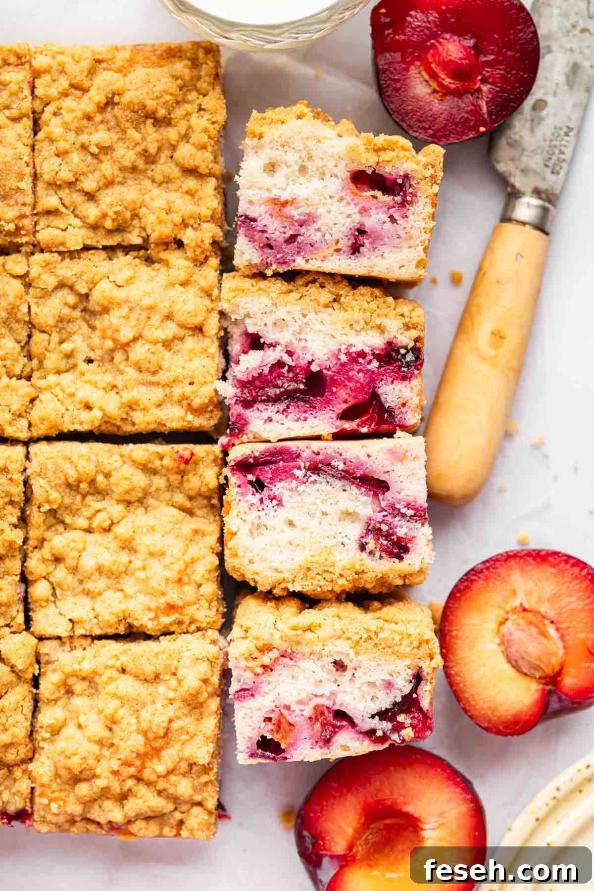 Overhead shot of plum cake with slices laying on side to show fruit bits in the cake.