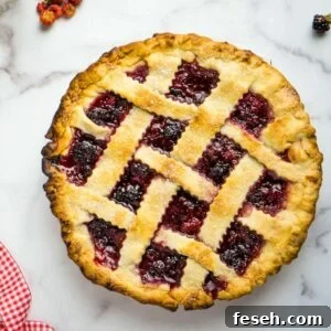 lattice-topped berry pie on marble counter.