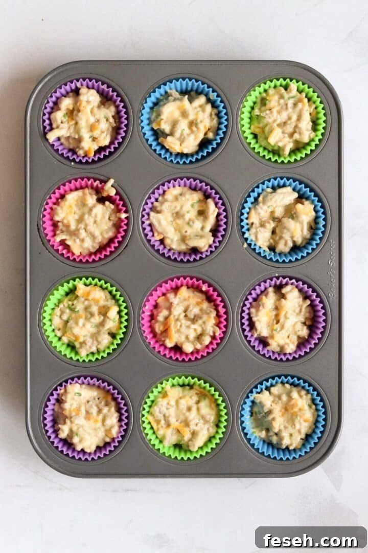 Muffin pan filled with raw sausage egg muffin batter