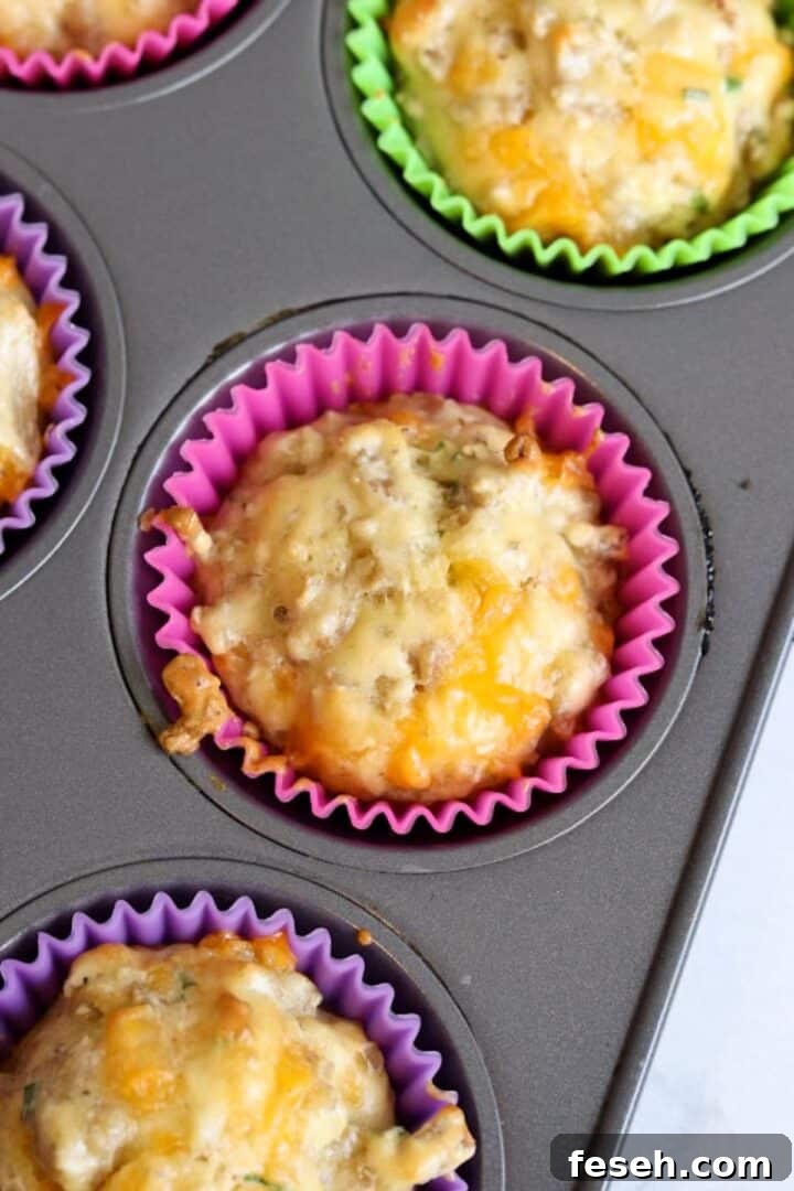 Cooked sausage cheese muffins in a muffin pan with silicone liners