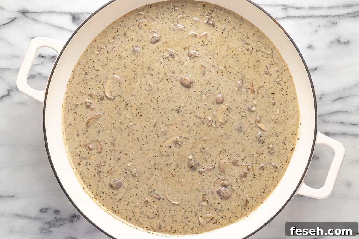 Creamy beef stroganoff sauce in a large pan. 