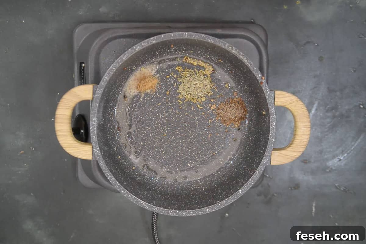 Cumin seeds, fennel seeds and hing added in the pan.