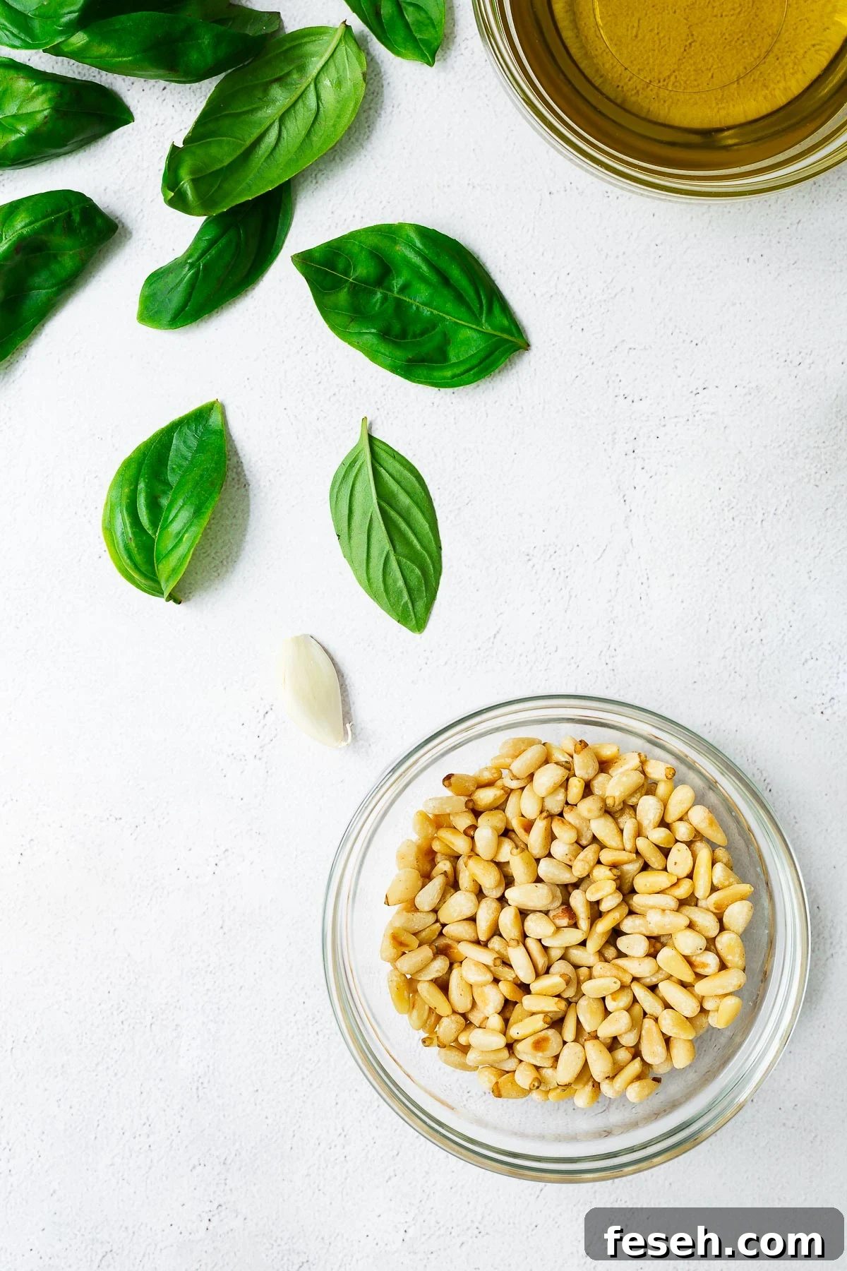 12 Great Pine Nut Substitutes for Pesto You’ll Love 3 Top down view of pine nuts and basil pesto ingredients.