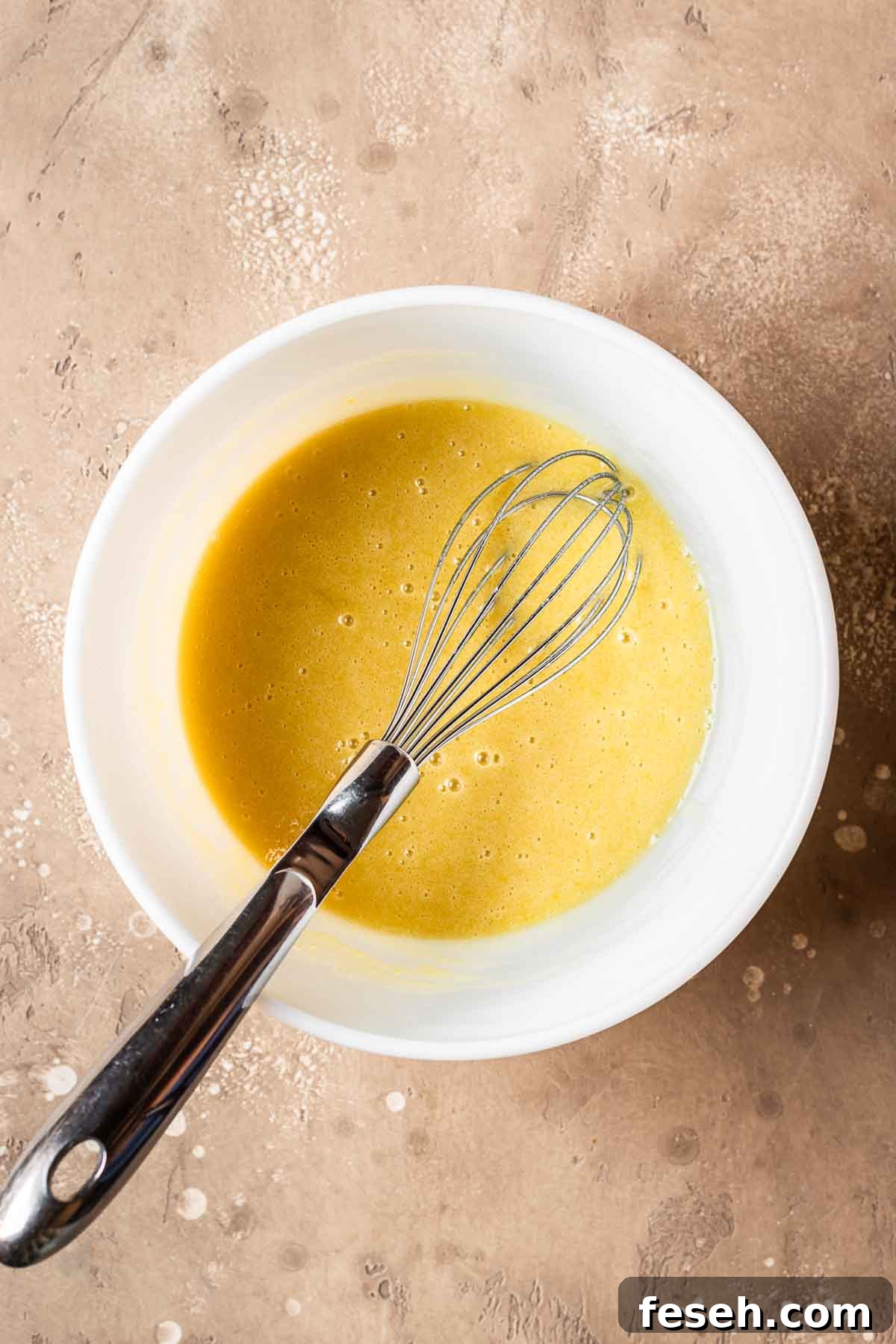 Wet ingredients fully whisked together in a ceramic bowl.