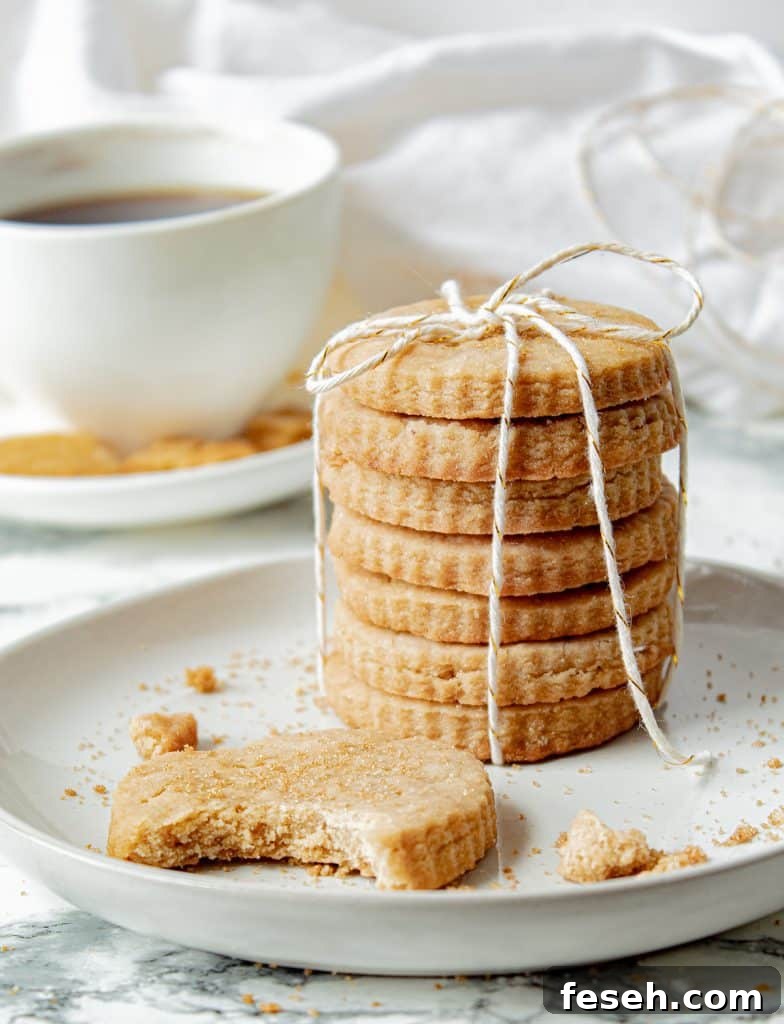 stack of brown sugar shortbread cookies tied with string, with a cup of coffee in the background