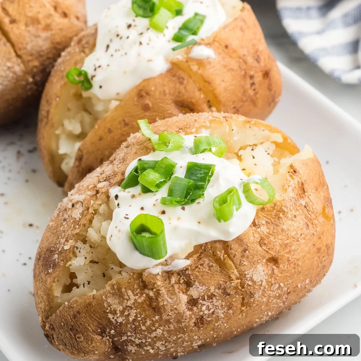 Baked potatoes with sour cream and green onions.