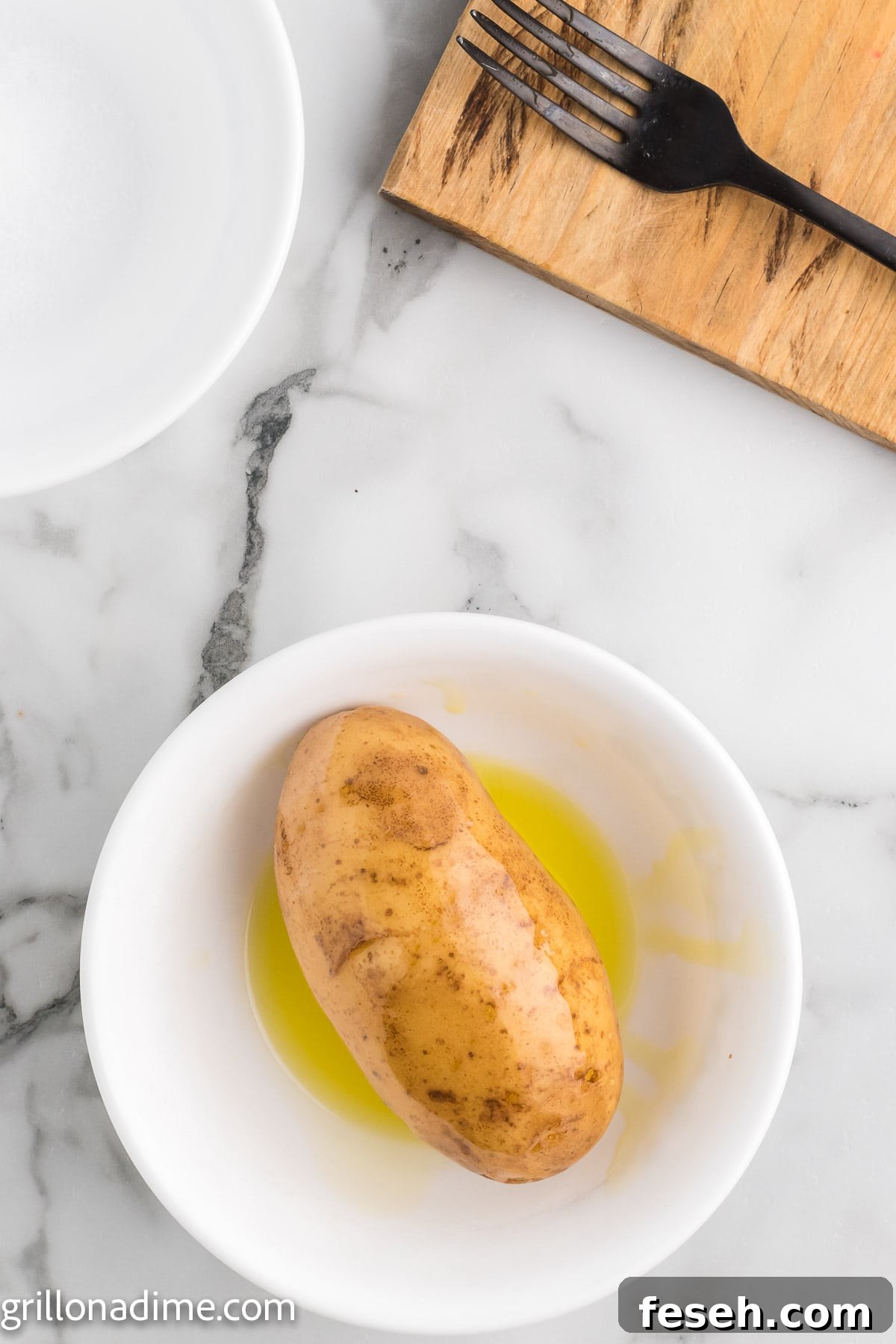 Bake potatoes being covered in a oil in a bowl