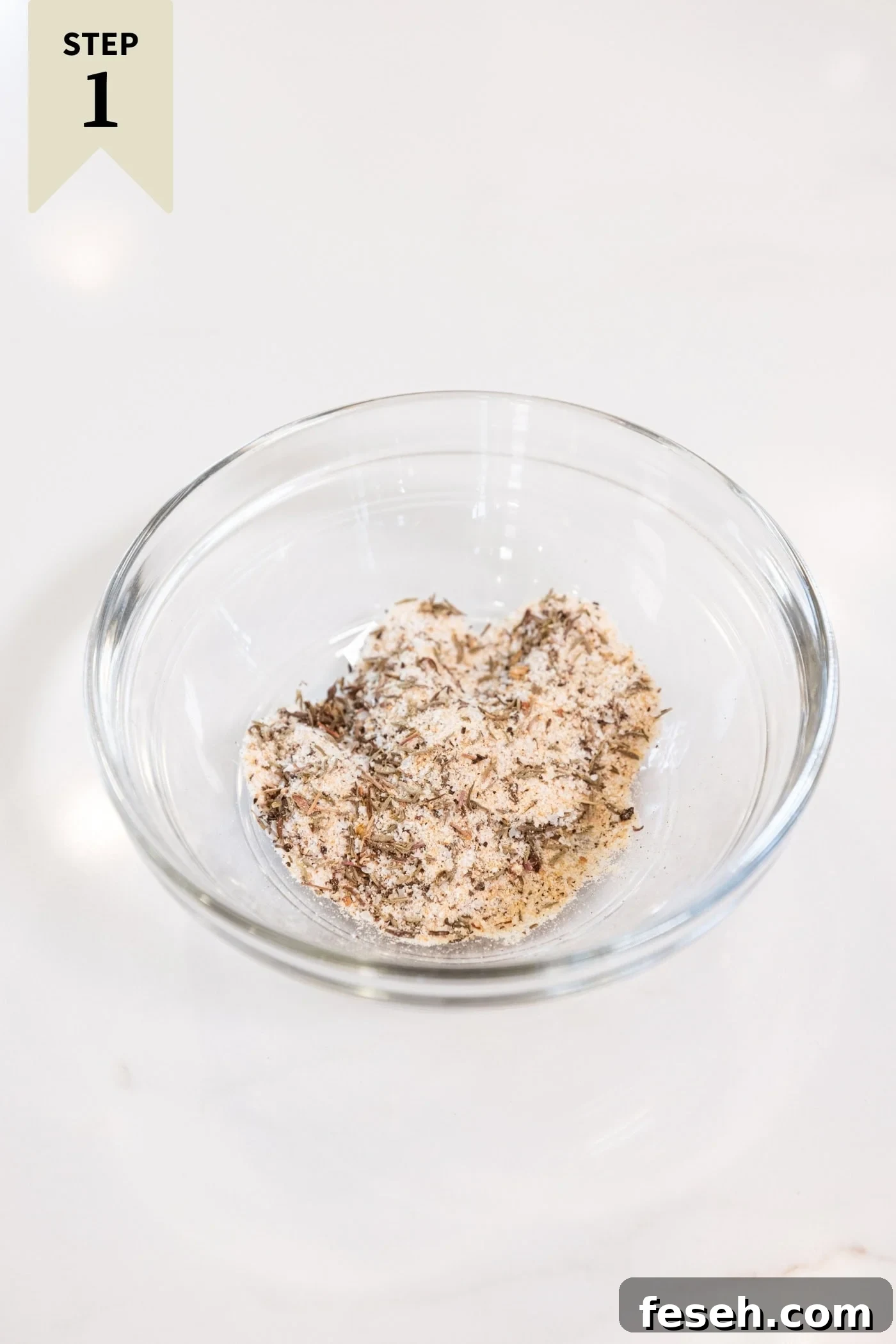 Small glass bowl filled with a dry rub to be added on top of raw chicken thighs to marinate them.