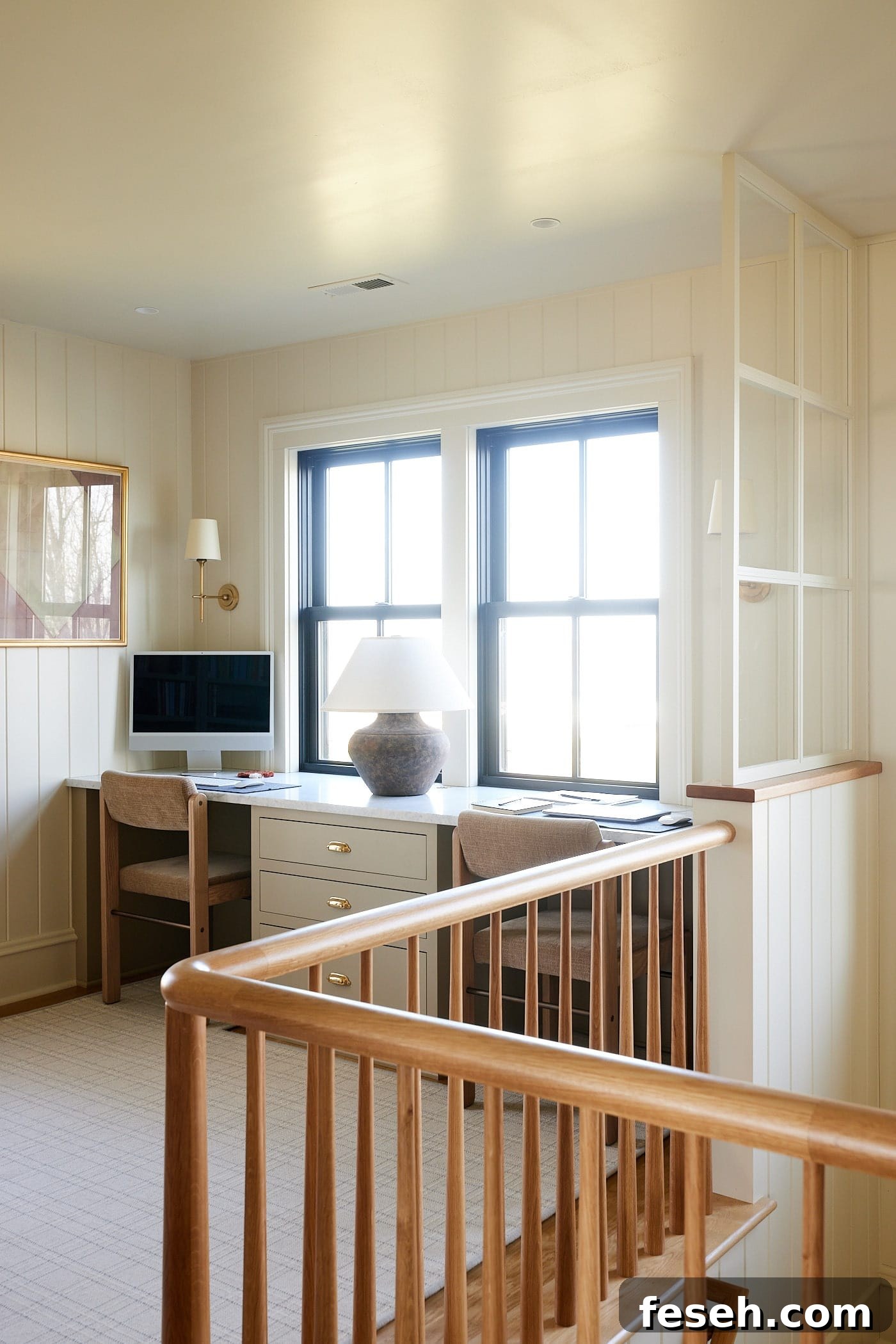 Upstairs office in farmhouse with two desk spaces in front of two large windows with white oak railing leading to downstairs.