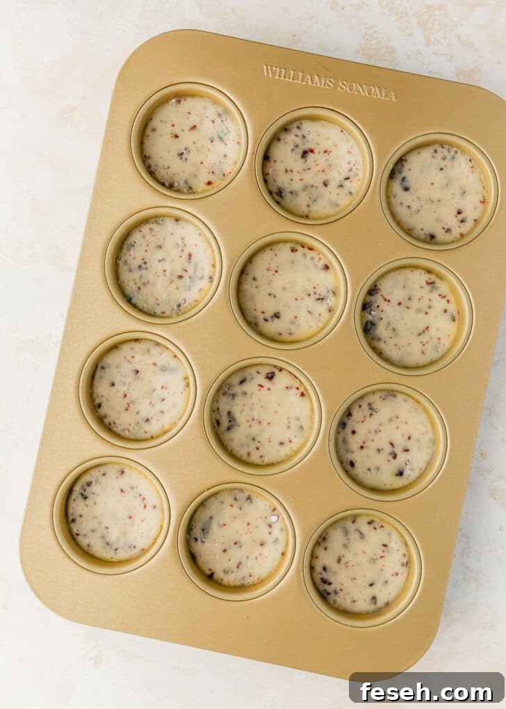 A gold pan of mini egg cheesecakes on a tan table.