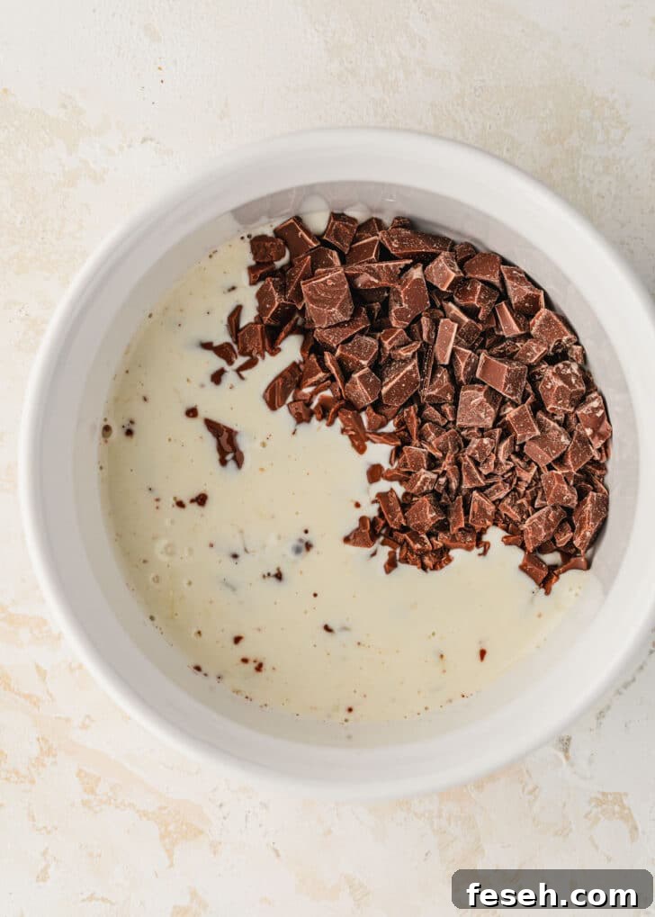 A white bowl of chocolate and cream on a tan counter.