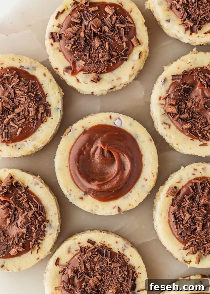 Mini egg cheesecakes with chocolate ganache on a marble platter.