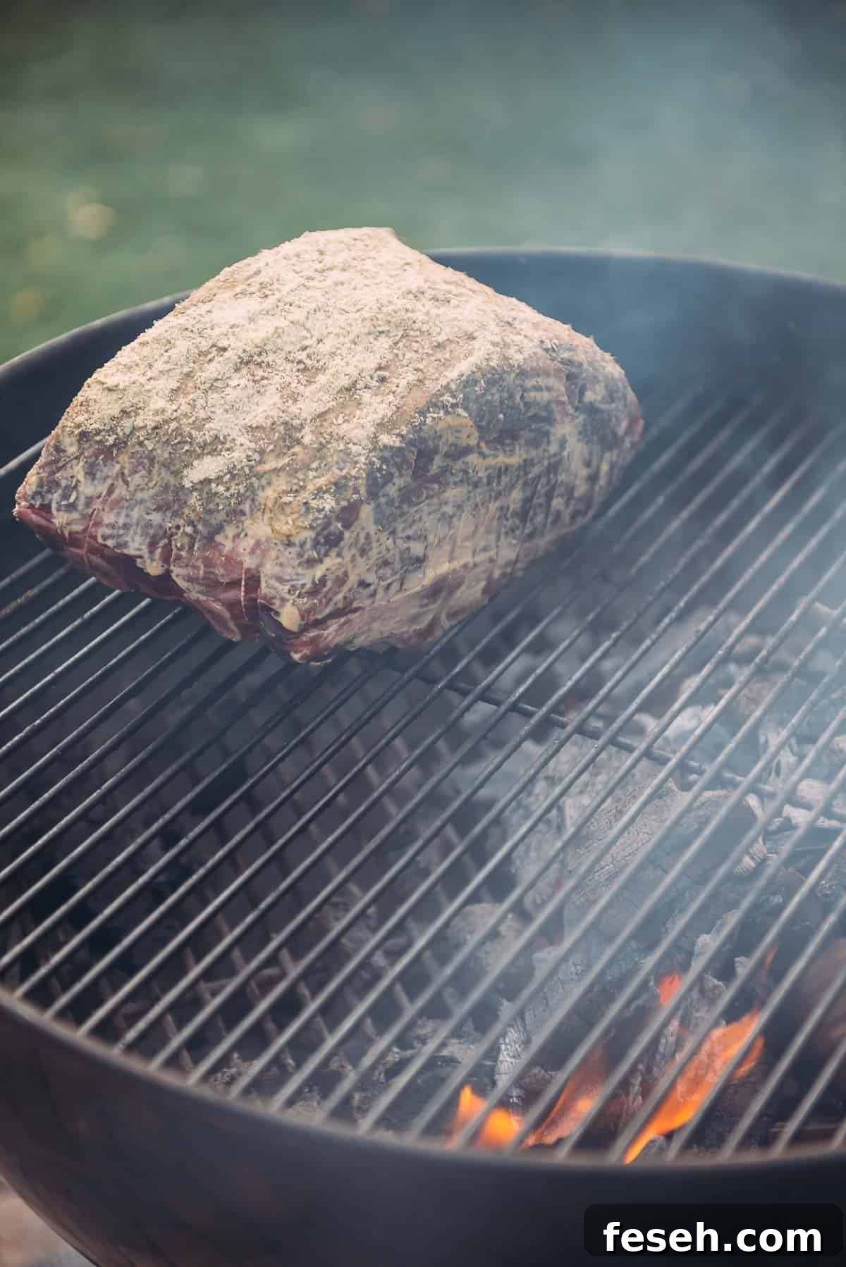 Perfect Grilled Prime Rib Recipe for Juicy, Flavorful Results 7 A standing rib roast is being cooked on a grill over indirect heat.